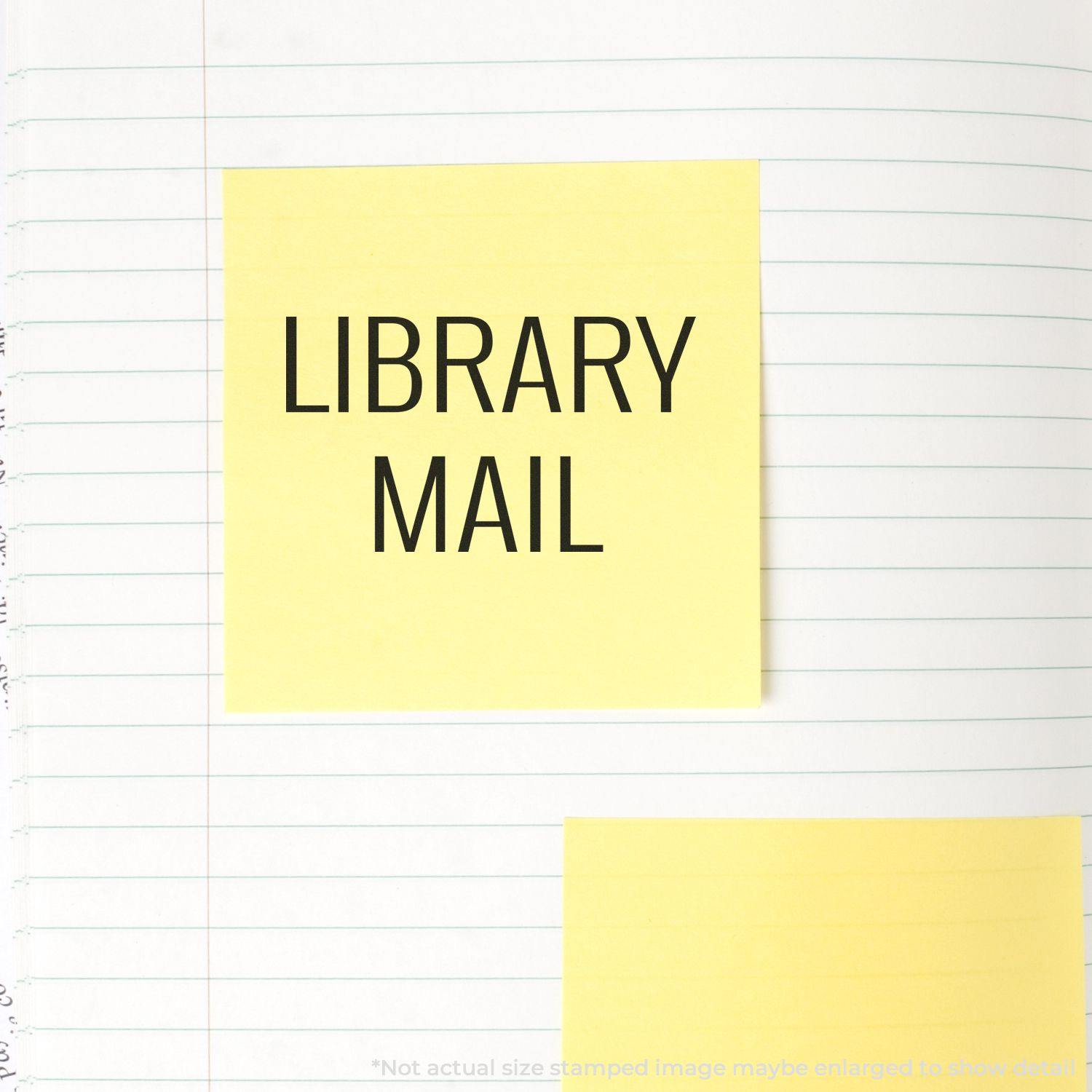 Large Library Mail Rubber Stamp used on a yellow sticky note placed on a lined notebook page.