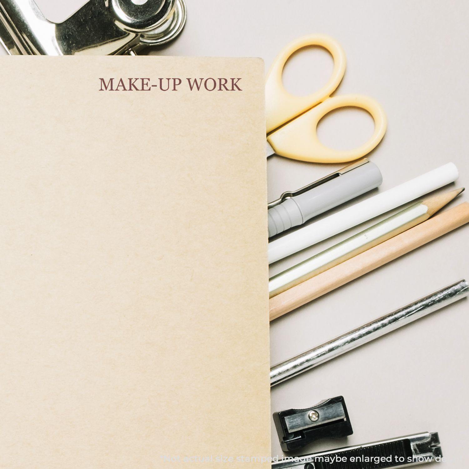 Large Make Up Work Rubber Stamp on a brown folder, surrounded by stationery items like scissors, pens, pencils, and a clipboard.