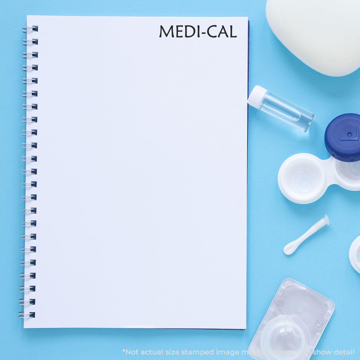 A notebook stamped with Medi-Cal on a blue background, surrounded by medical supplies including a vial, contact lens case, and cotton swab.