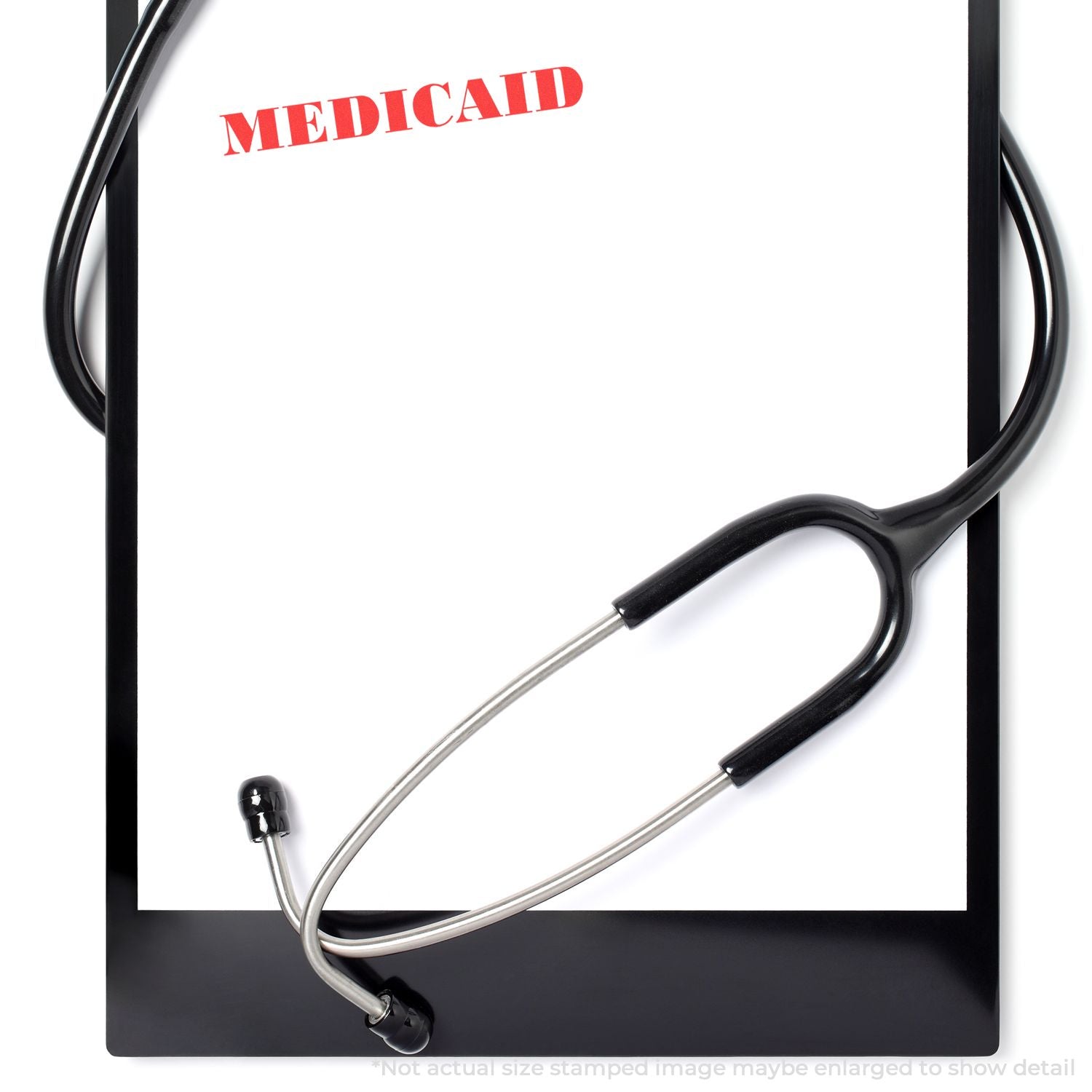 Self Inking Medicaid Stamp imprint on a white clipboard with a stethoscope draped over it.