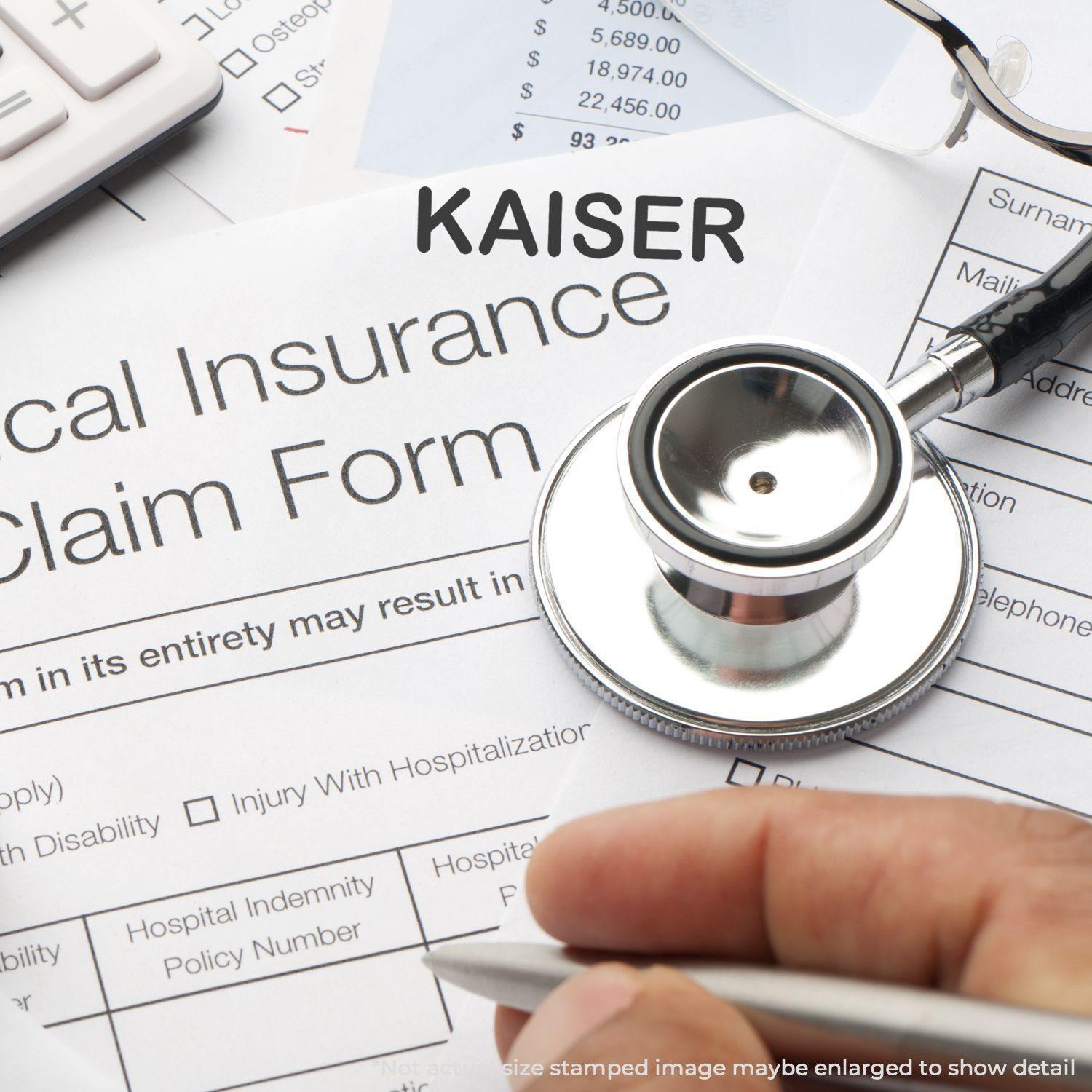 A Large Self Inking Kaiser Stamp is shown in use on a medical insurance claim form, with a stethoscope and calculator nearby.