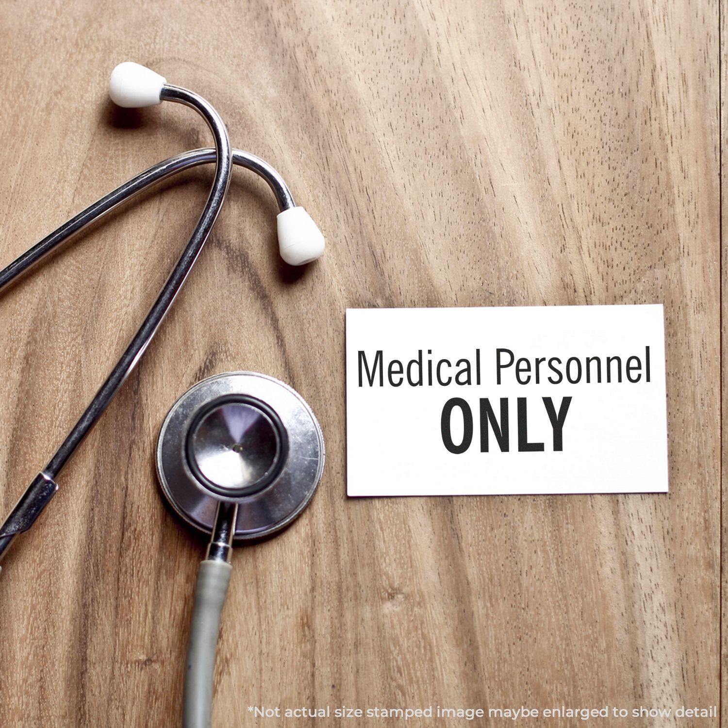 Medical Personnel Only Rubber Stamp on a wooden surface next to a stethoscope, emphasizing restricted access for medical staff.