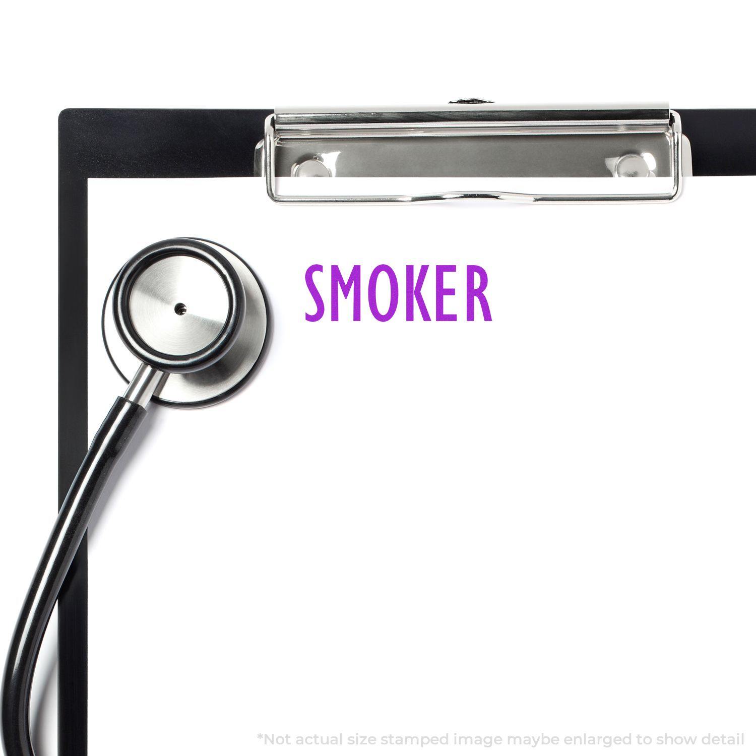 Clipboard with stethoscope and Large Pre-Inked Smoker Stamp marking SMOKER in purple ink on a white sheet.