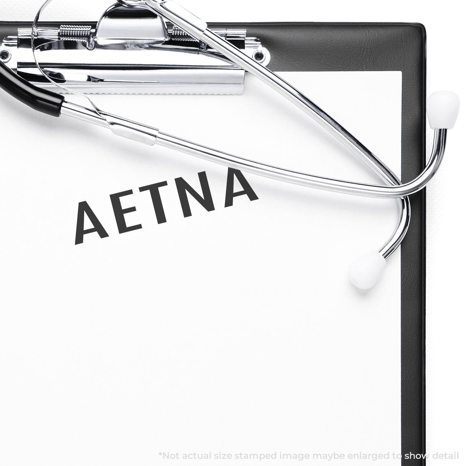 Large Aetna Rubber Stamp imprint on a clipboard with a stethoscope, demonstrating its use in a medical setting."