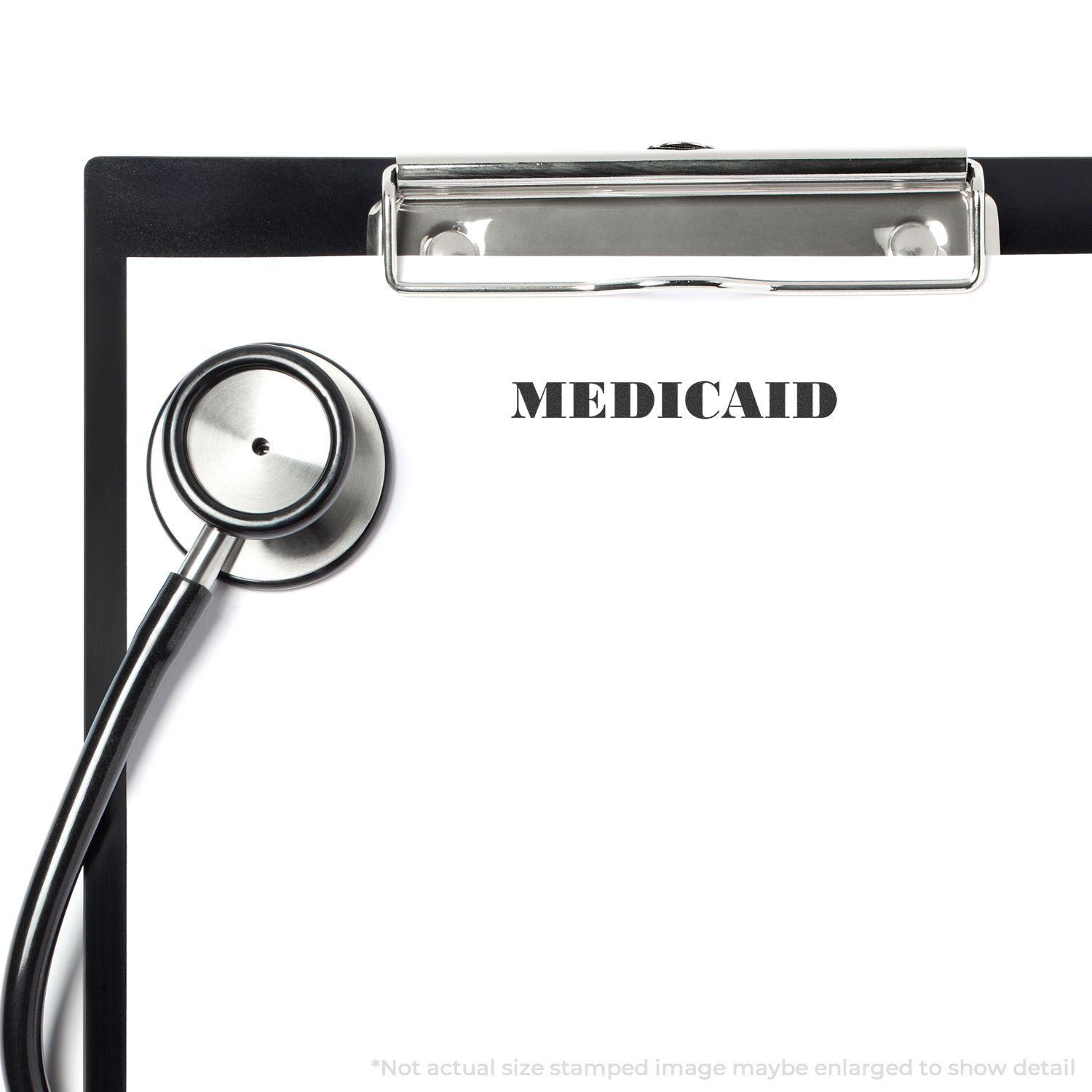 Clipboard with MEDICAID stamped using the Large Self Inking Medicare Stamp, accompanied by a stethoscope.