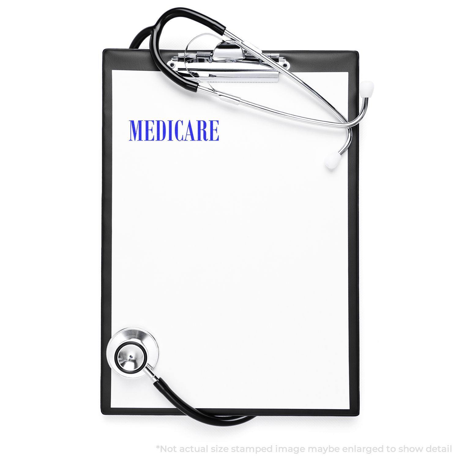 A clipboard with a stethoscope and a Large Medicare Rubber Stamp imprinting MEDICARE on a blank sheet of paper.