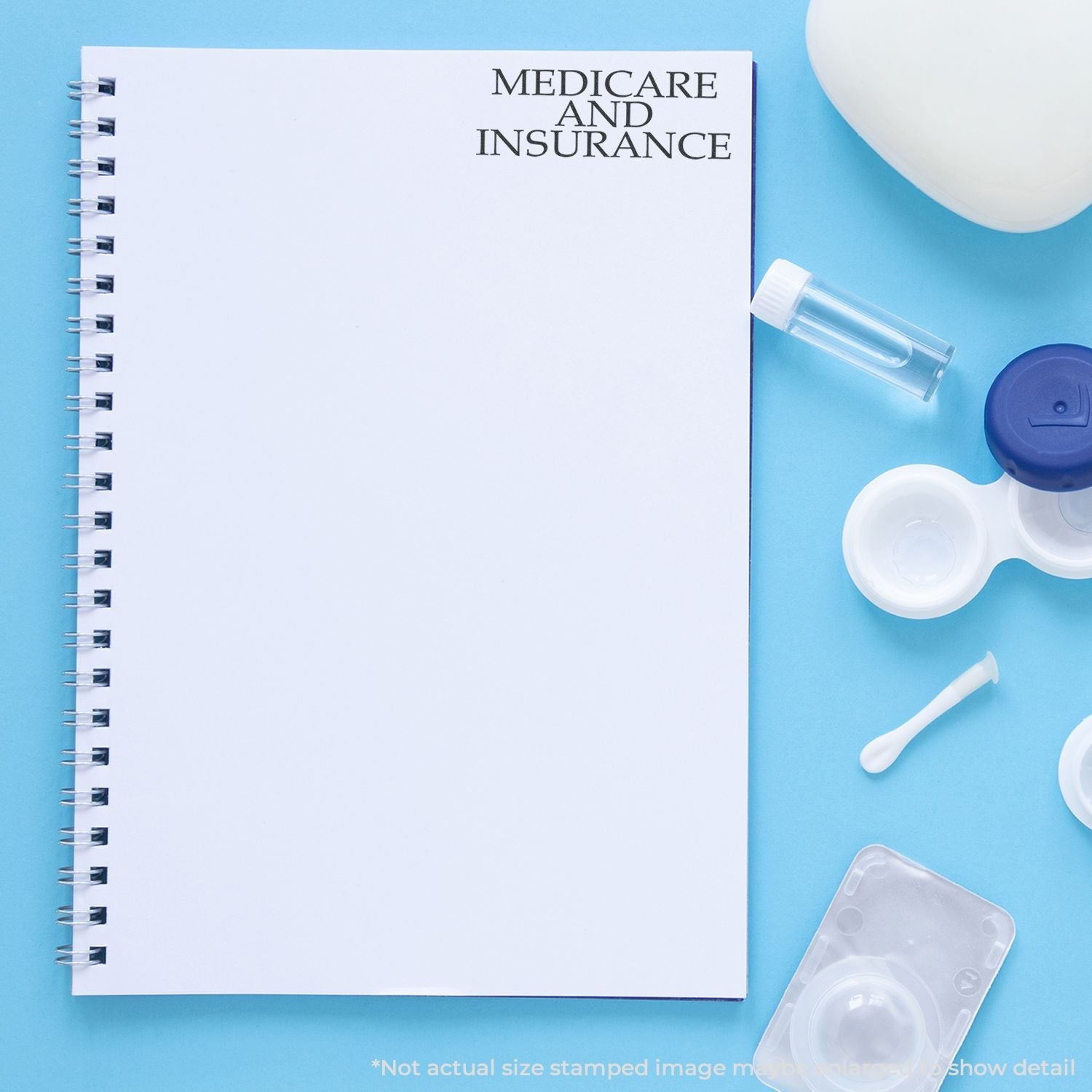 Self Inking Medicare And Insurance Stamp used on a white notebook, surrounded by medical items on a blue background.