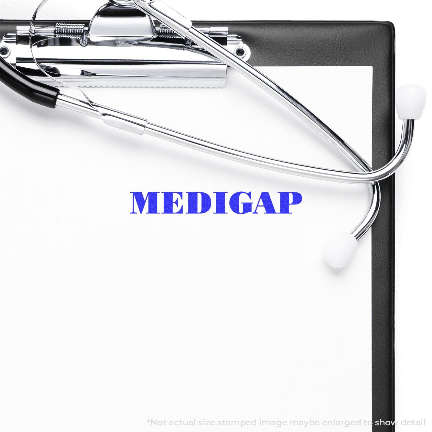 A clipboard with a stethoscope and a Large Medigap Rubber Stamp imprint in blue ink on a white paper.