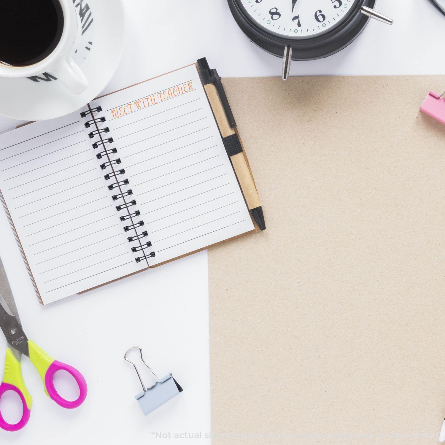 A desk with a notebook stamped Meet With Teacher, scissors, a binder clip, a clock, and a coffee cup. Product: Large Meet With Teacher Rubber Stamp.