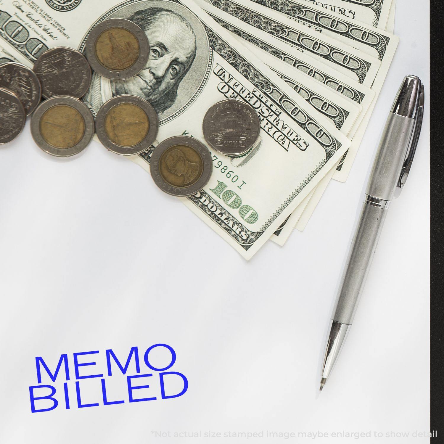 Large Memo Billed Rubber Stamp in blue ink on paper, surrounded by a pen, coins, and dollar bills.