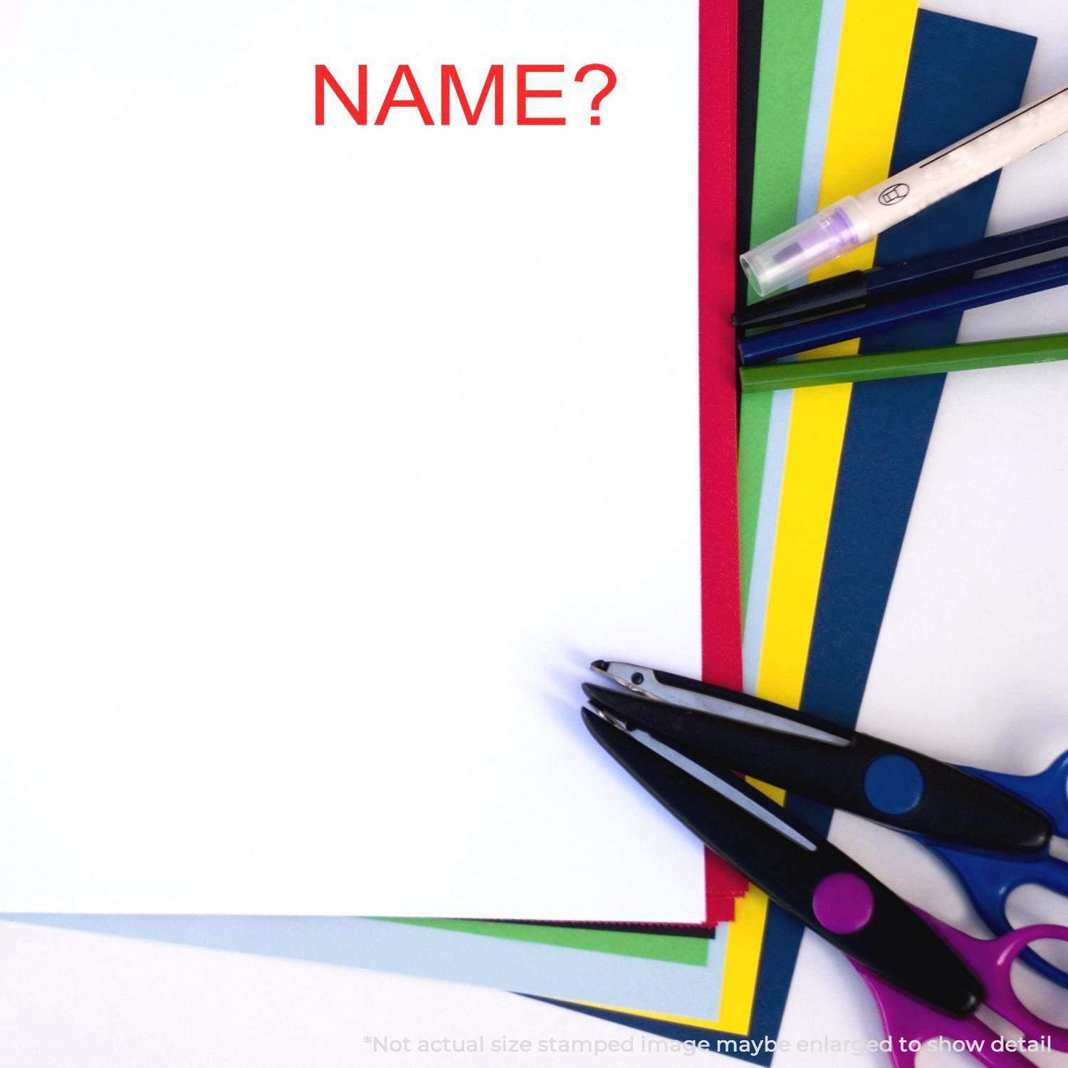 A name rubber stamp is placed on a stack of colorful papers with scissors and pens nearby, ready for use.