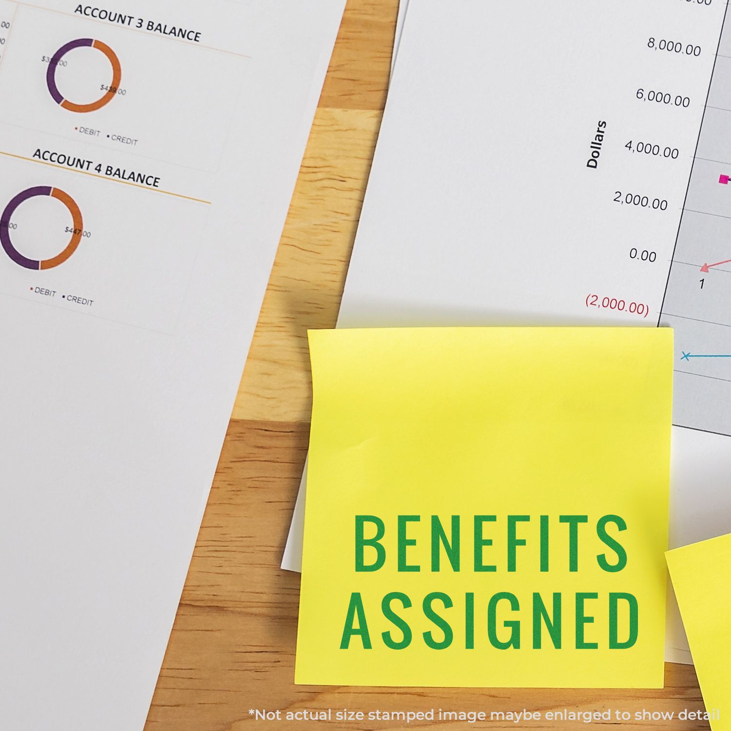 Self Inking Narrow Benefits Assigned Stamp used on a yellow sticky note, placed on financial documents with charts and graphs.