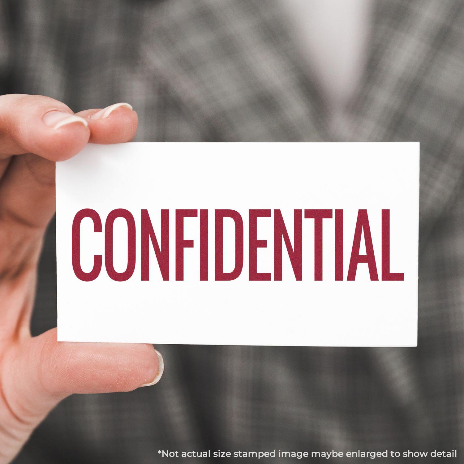 Hand holding a card with a red CONFIDENTIAL stamp, demonstrating the use of a narrow confidential rubber stamp.