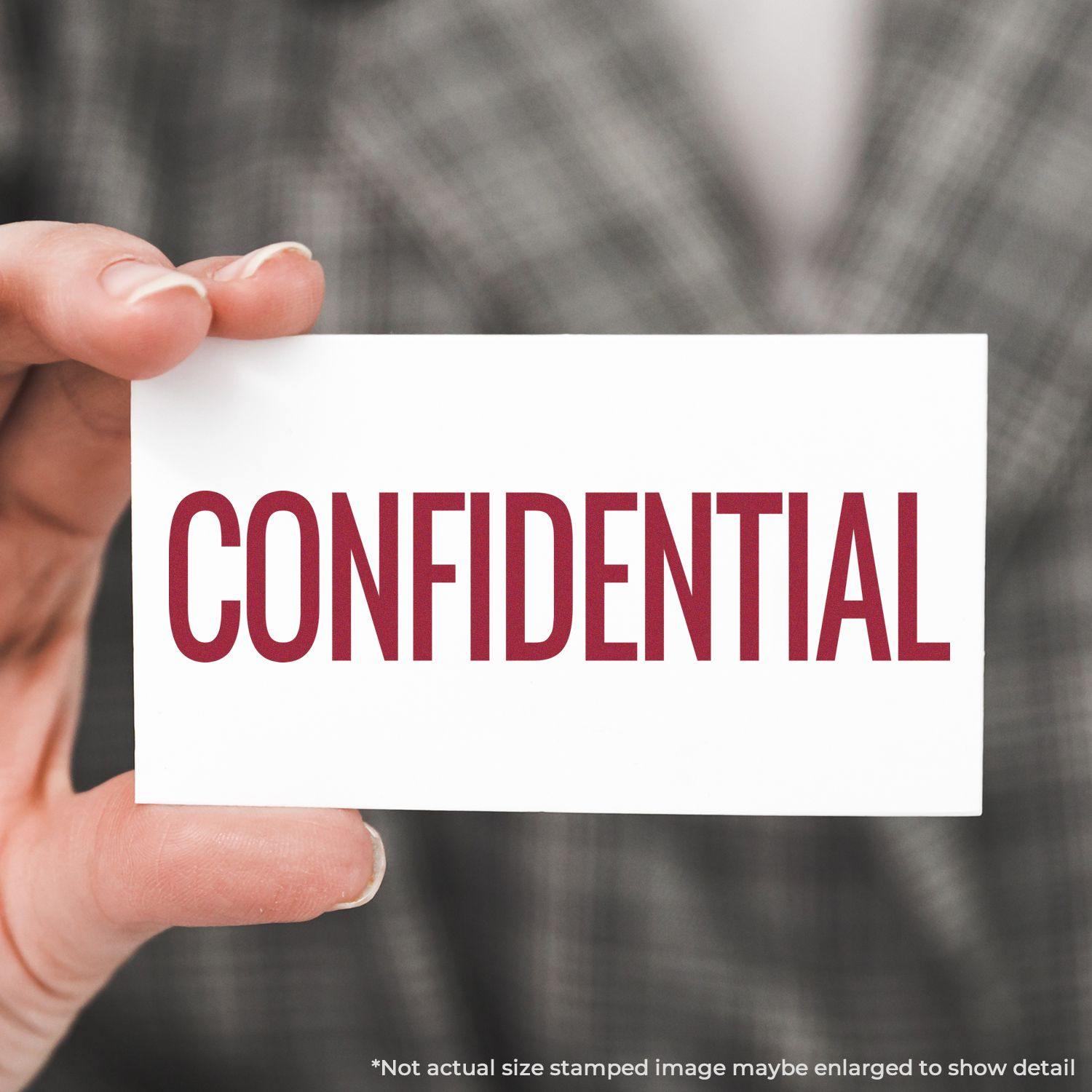 A stock office rubber stamp with a stamped image showing how the text "CONFIDENTIAL" in a narrow font is displayed after stamping.