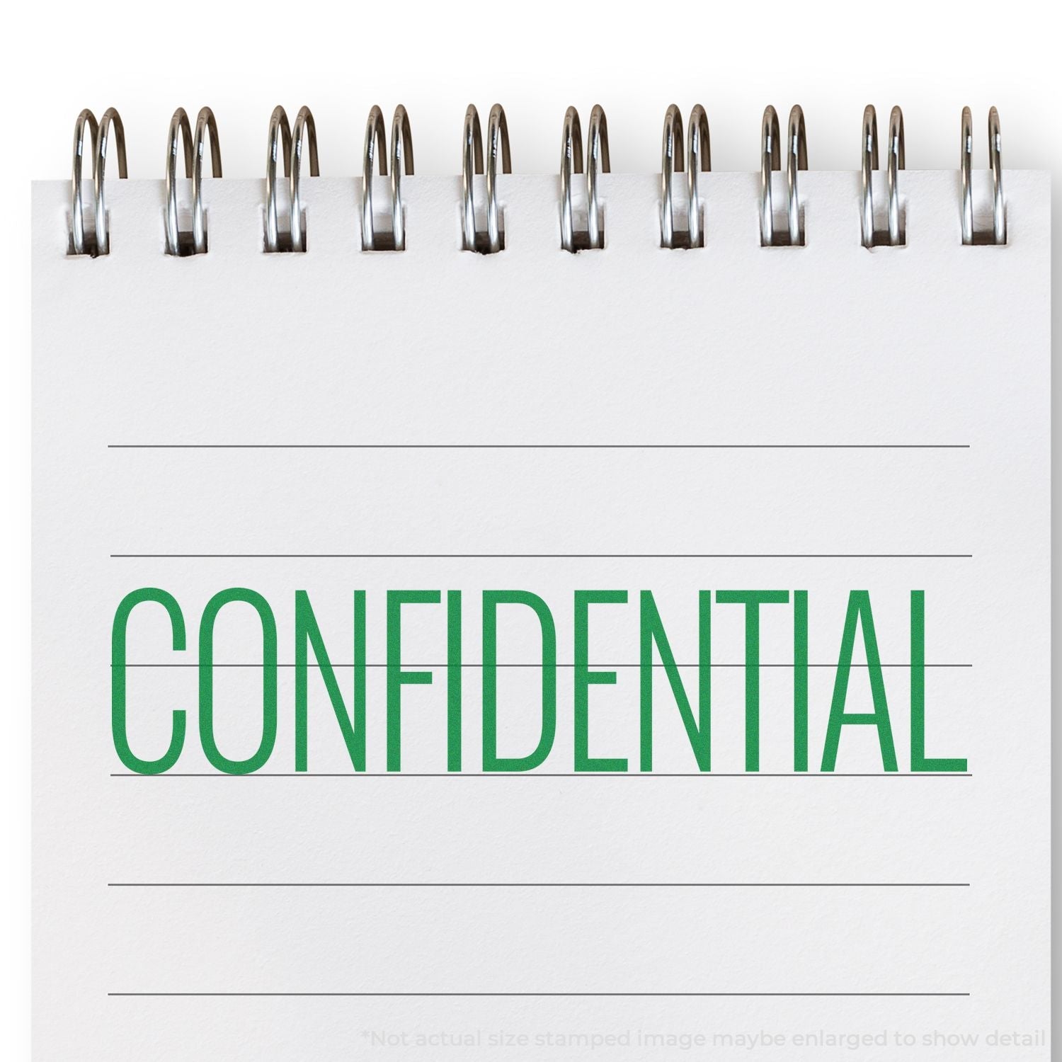 Self Inking Narrow Font Confidential Stamp marking CONFIDENTIAL in green on a white spiral notebook with lined paper.