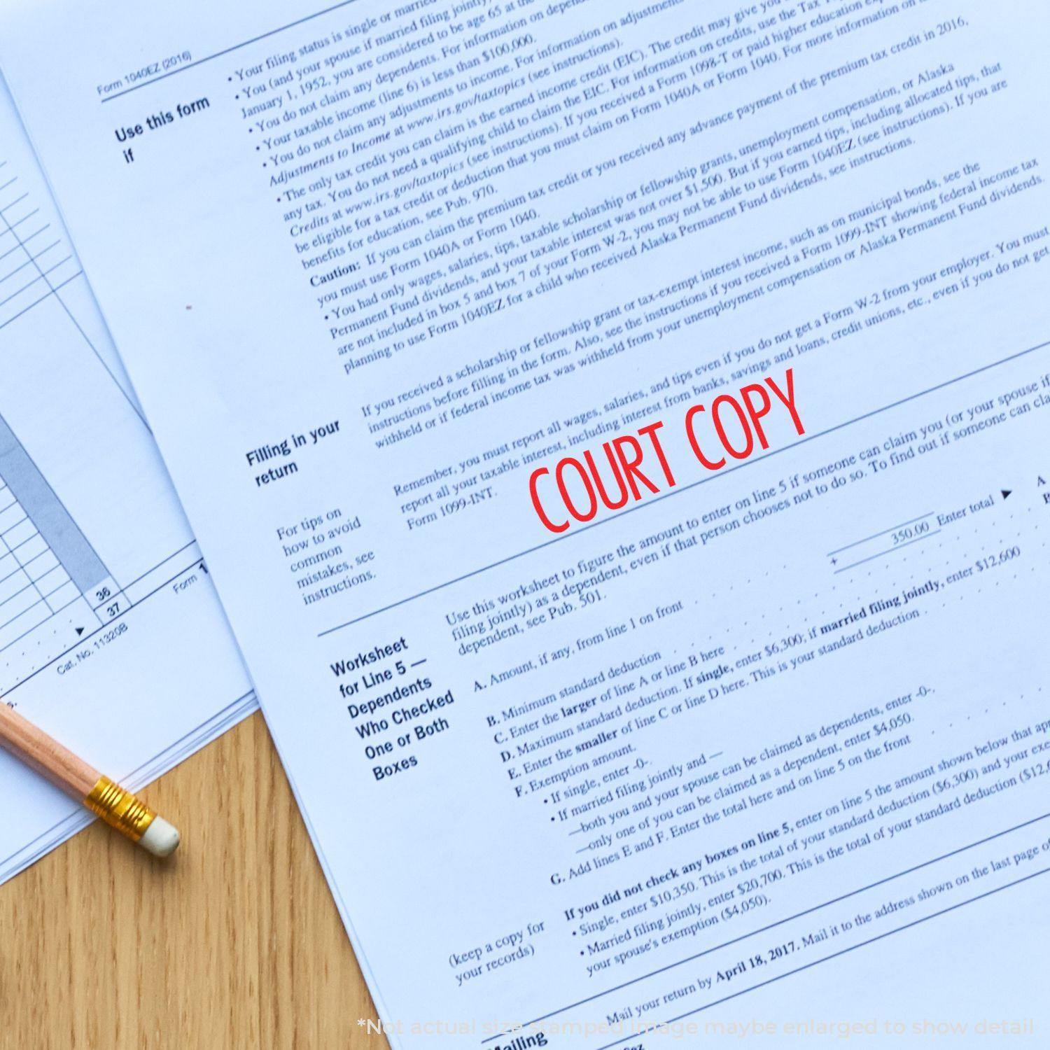 Large Pre-Inked Narrow Font Court Copy Stamp in red ink on a document, with a pencil and other papers on a wooden surface.