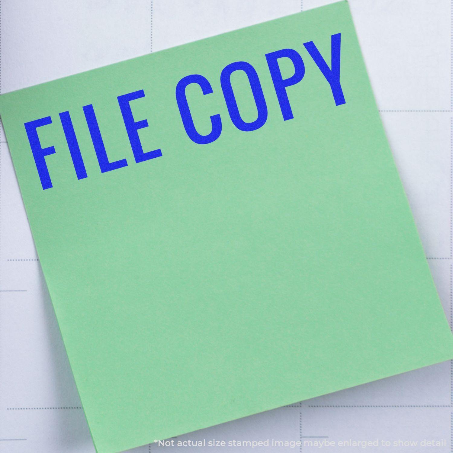 A stock office rubber stamp with a stamped image showing how the text "FILE COPY" in a large narrow font is displayed after stamping.