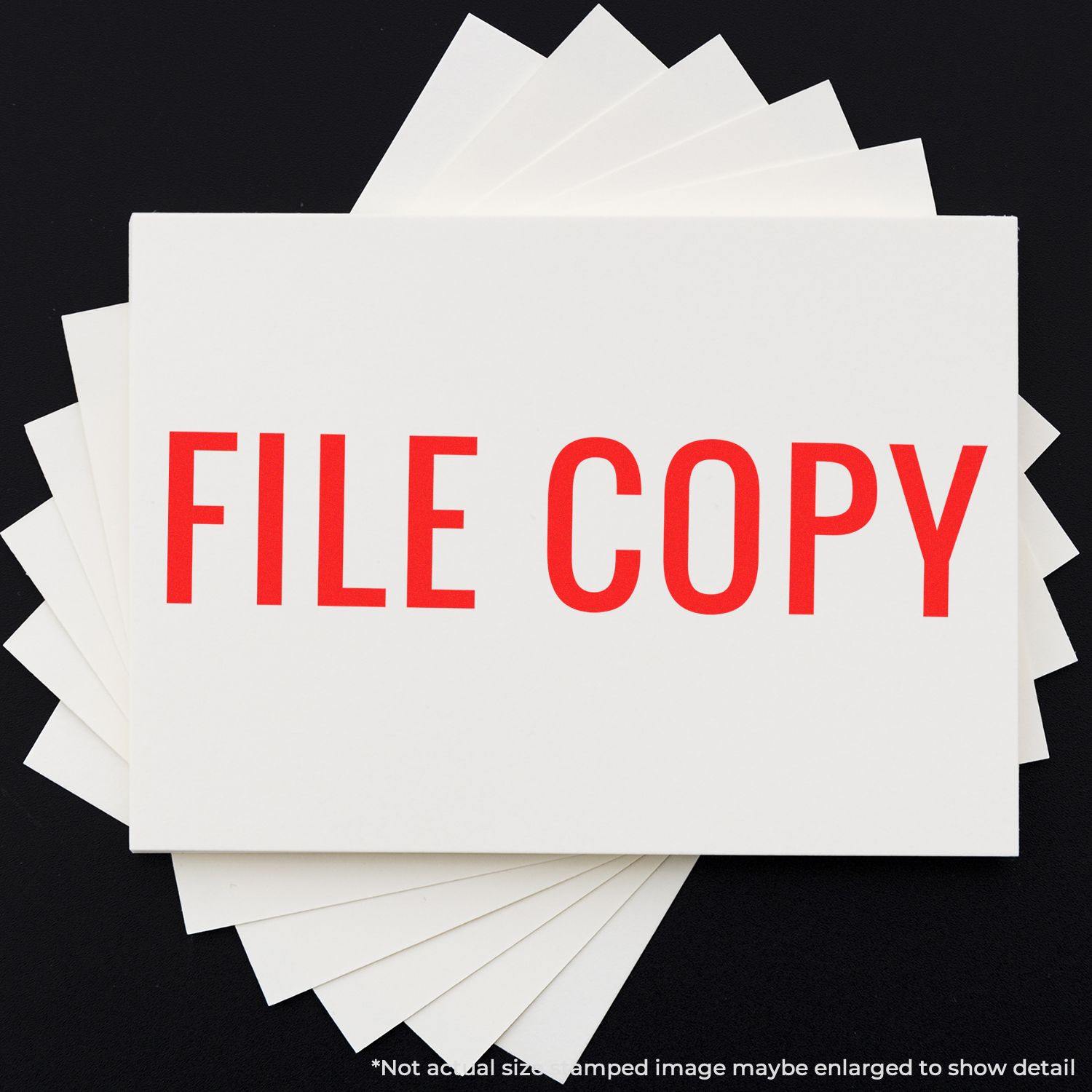 Large Narrow Font File Copy Rubber Stamp in red ink on white paper, with multiple sheets fanned out underneath.