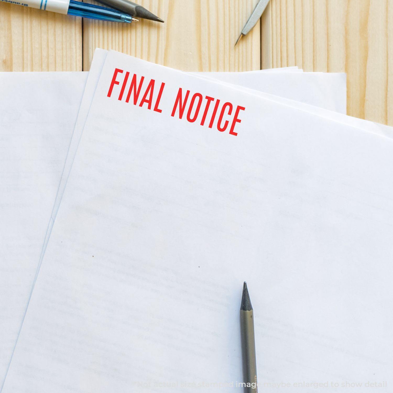 A stack of papers stamped with FINAL NOTICE in red, using a narrow font rubber stamp, placed on a wooden desk with pens.