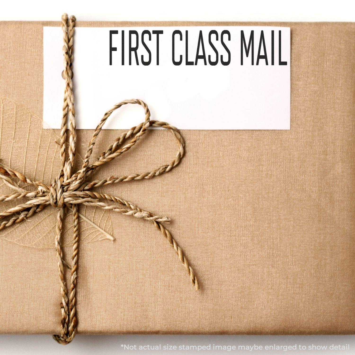 A package wrapped in brown paper with a rope bow and a First Class Mail label stamped in a narrow font.