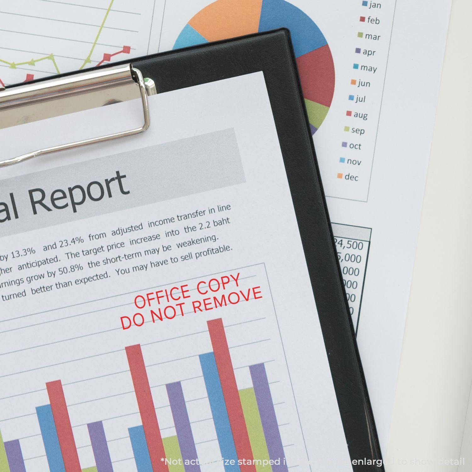 A clipboard with a financial report stamped in red with OFFICE COPY DO NOT REMOVE using a narrow font rubber stamp.