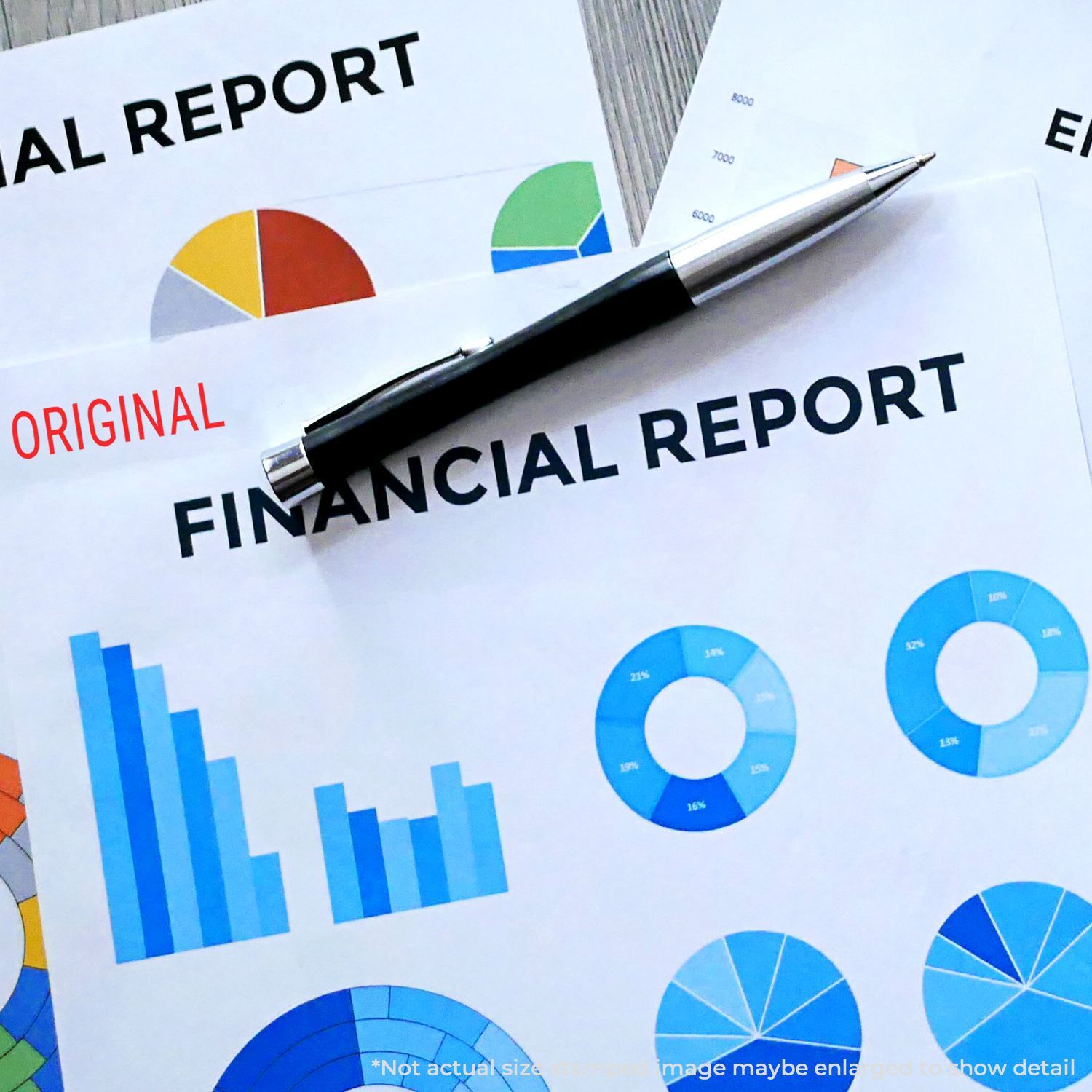 Financial reports stamped with Self Inking Narrow Font Original Stamp, featuring colorful charts and a pen on a desk.