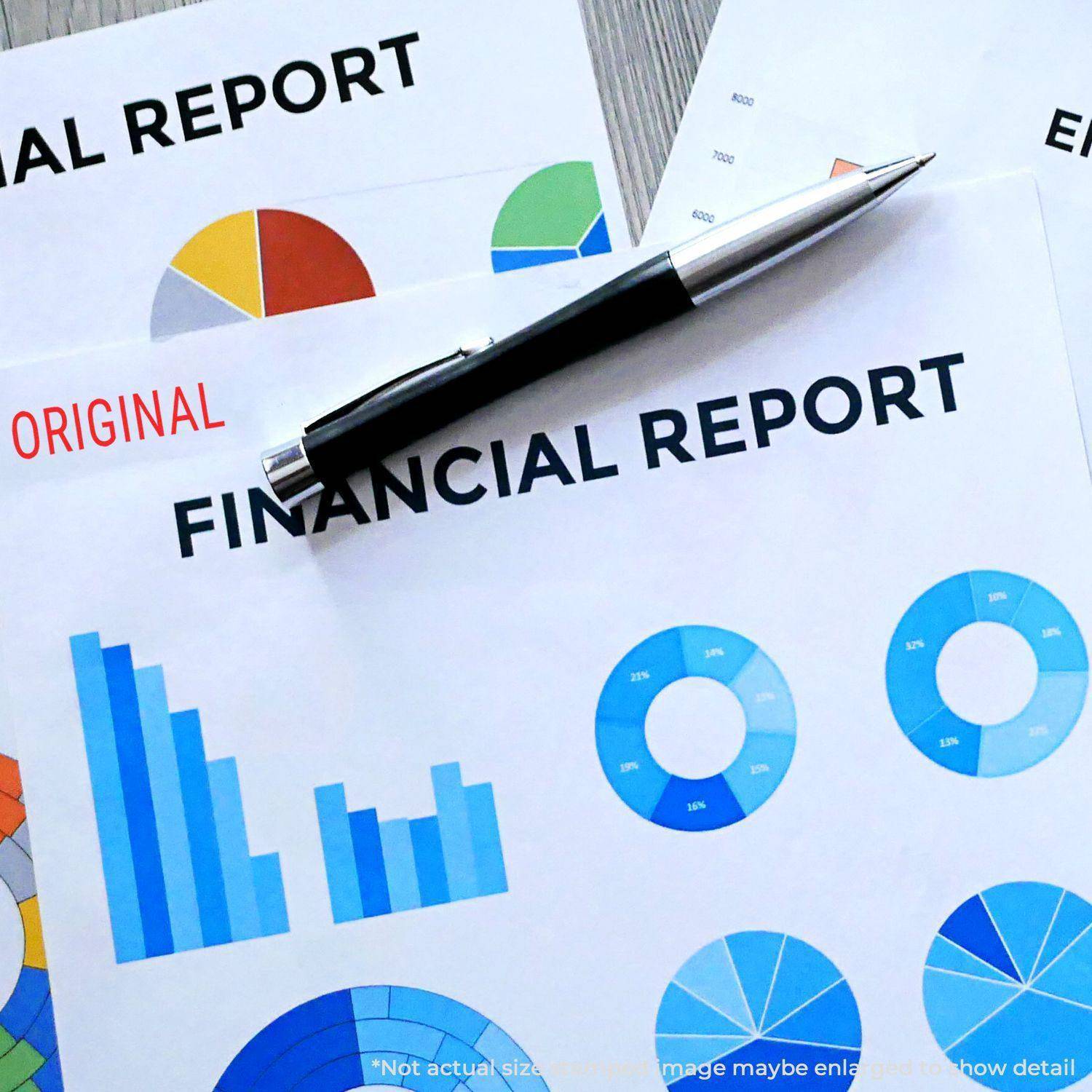 Large Pre-Inked Narrow Font Original Stamp marking ORIGINAL on financial reports with colorful charts and a pen on top.