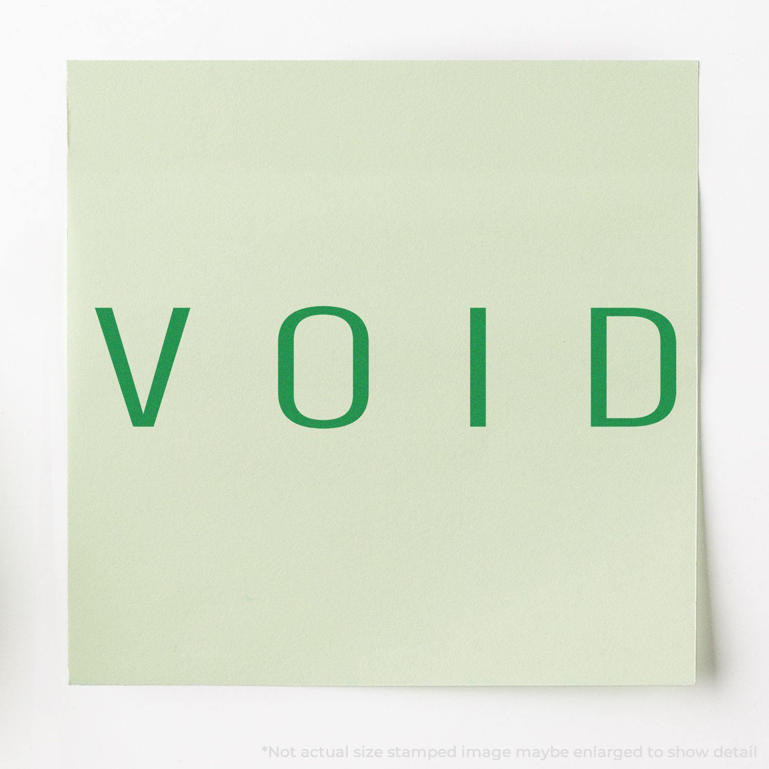 Large Self Inking Narrow Void Stamp in use, displaying the word VOID in green on a light green paper.