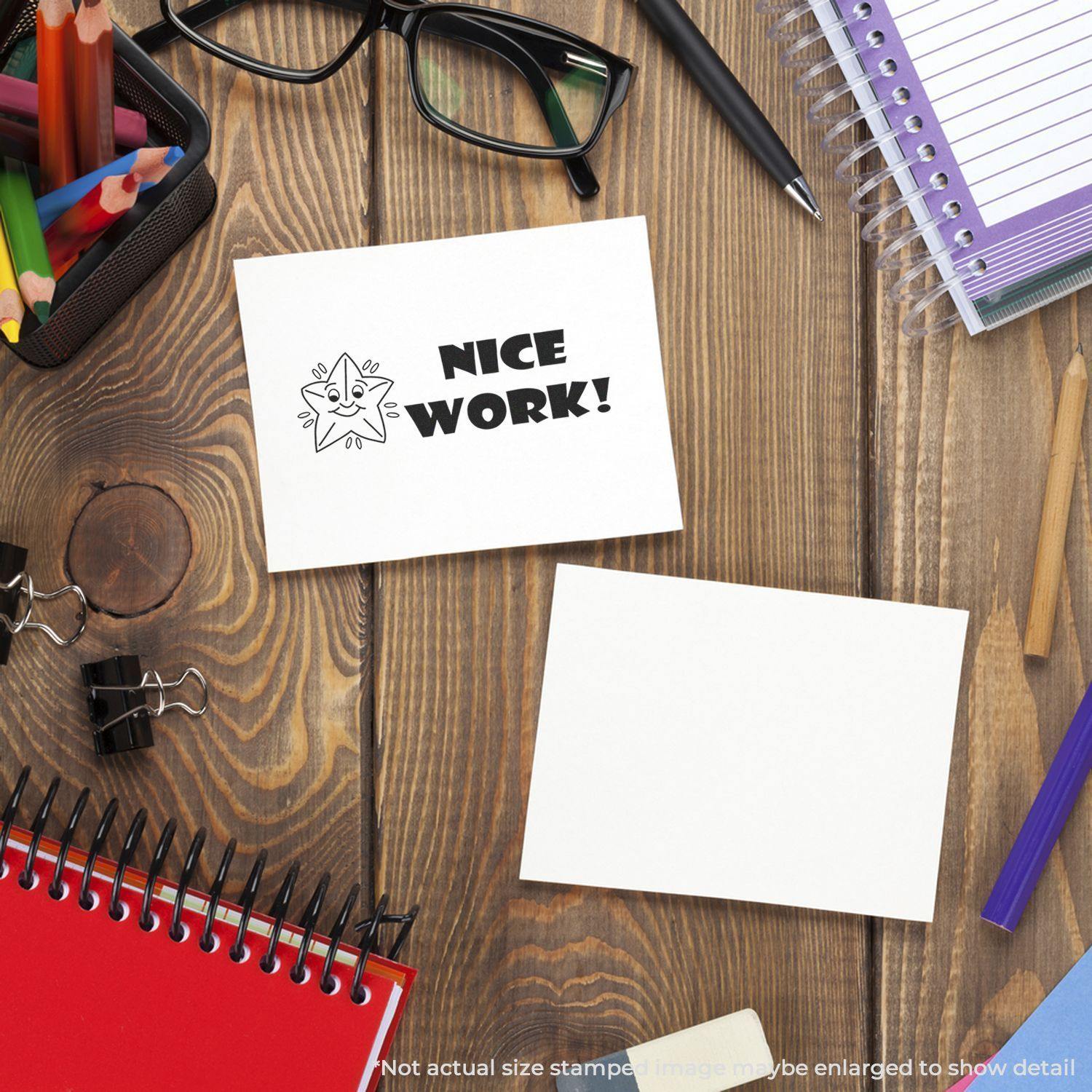 Desk with stationery, glasses, and a Large Nice Work Rubber Stamp on a card, surrounded by notebooks and pens.