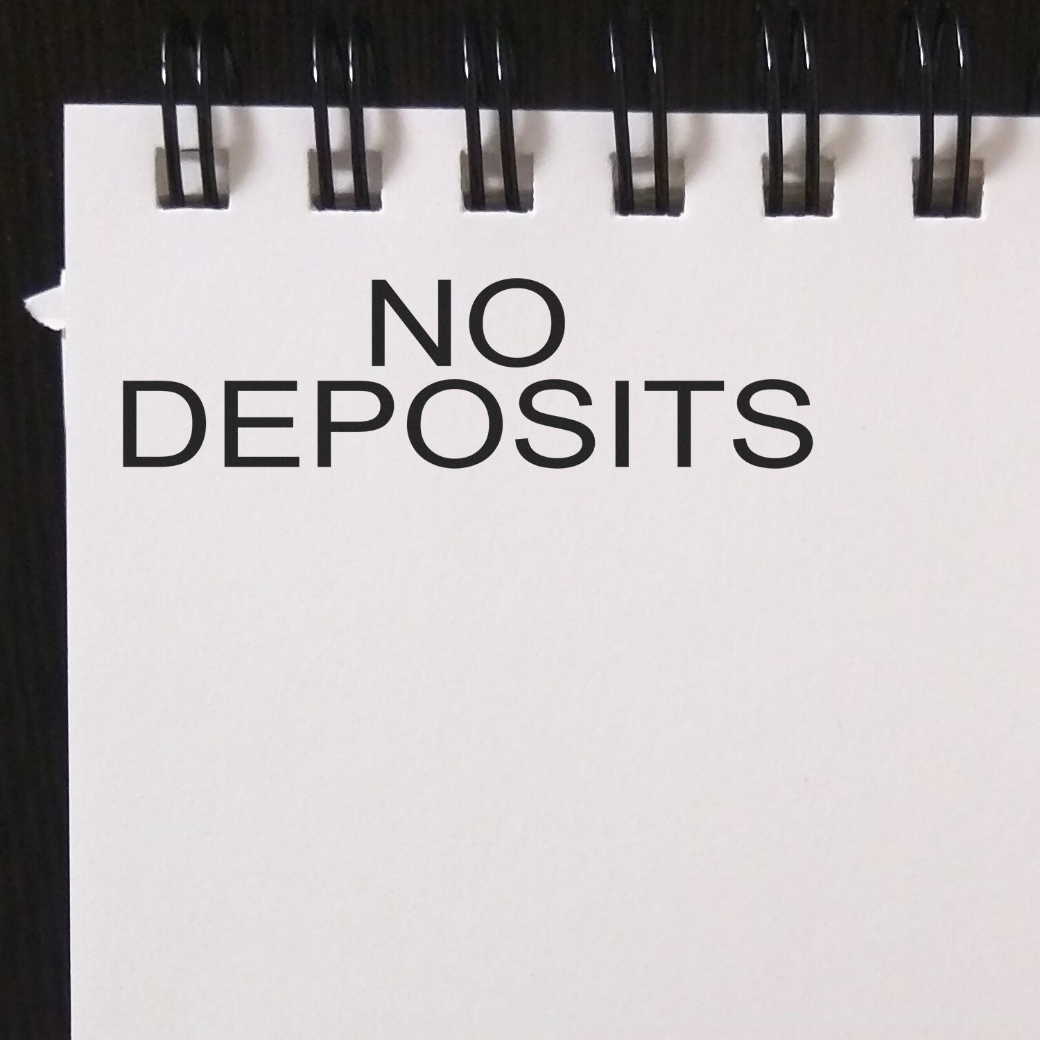 A self-inking stamp with a stamped image showing how the text "NO DEPOSITS" is displayed after stamping.