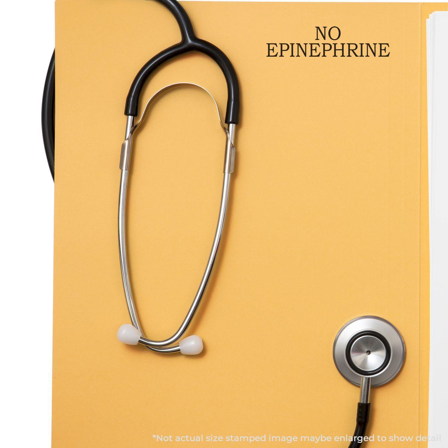 A stethoscope on a yellow folder stamped with NO EPINEPHRINE using the Large No Epinephrine Rubber Stamp.