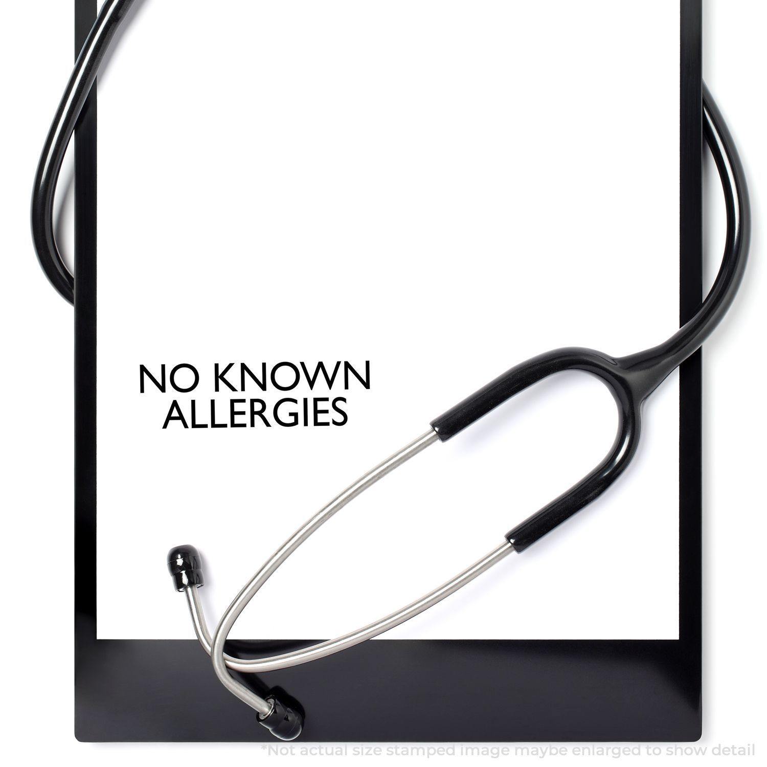 No Known Allergies Rubber Stamp on white paper with a black stethoscope wrapped around it, indicating medical clearance.