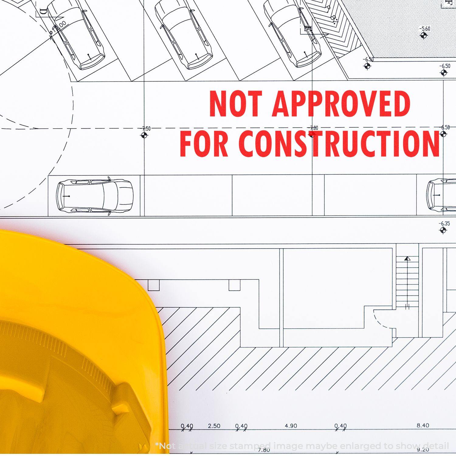 A Not Approved For Construction rubber stamp on architectural blueprints with a yellow hard hat in the foreground.