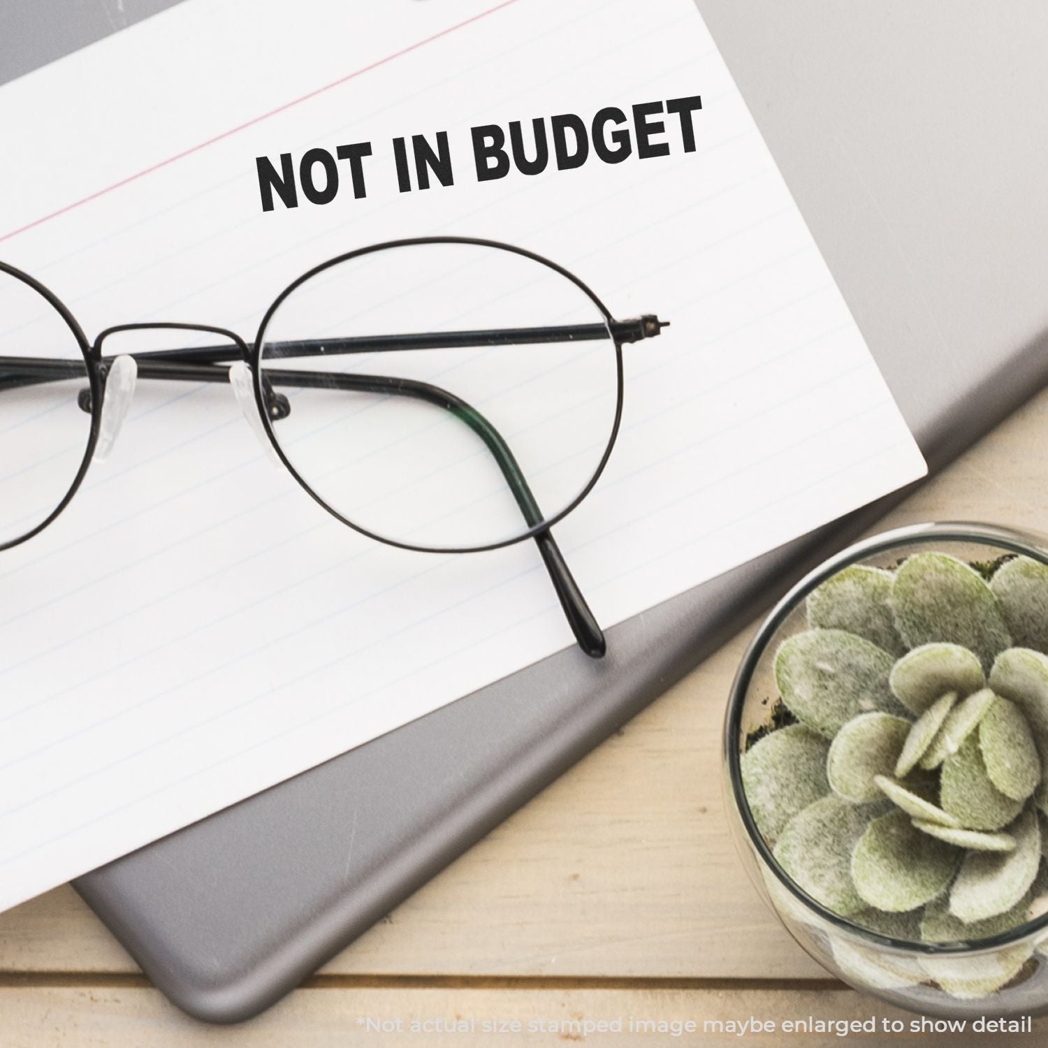 Glasses and a succulent beside a stamped paper with NOT IN BUDGET using the Self Inking Not In Budget Stamp on a desk.