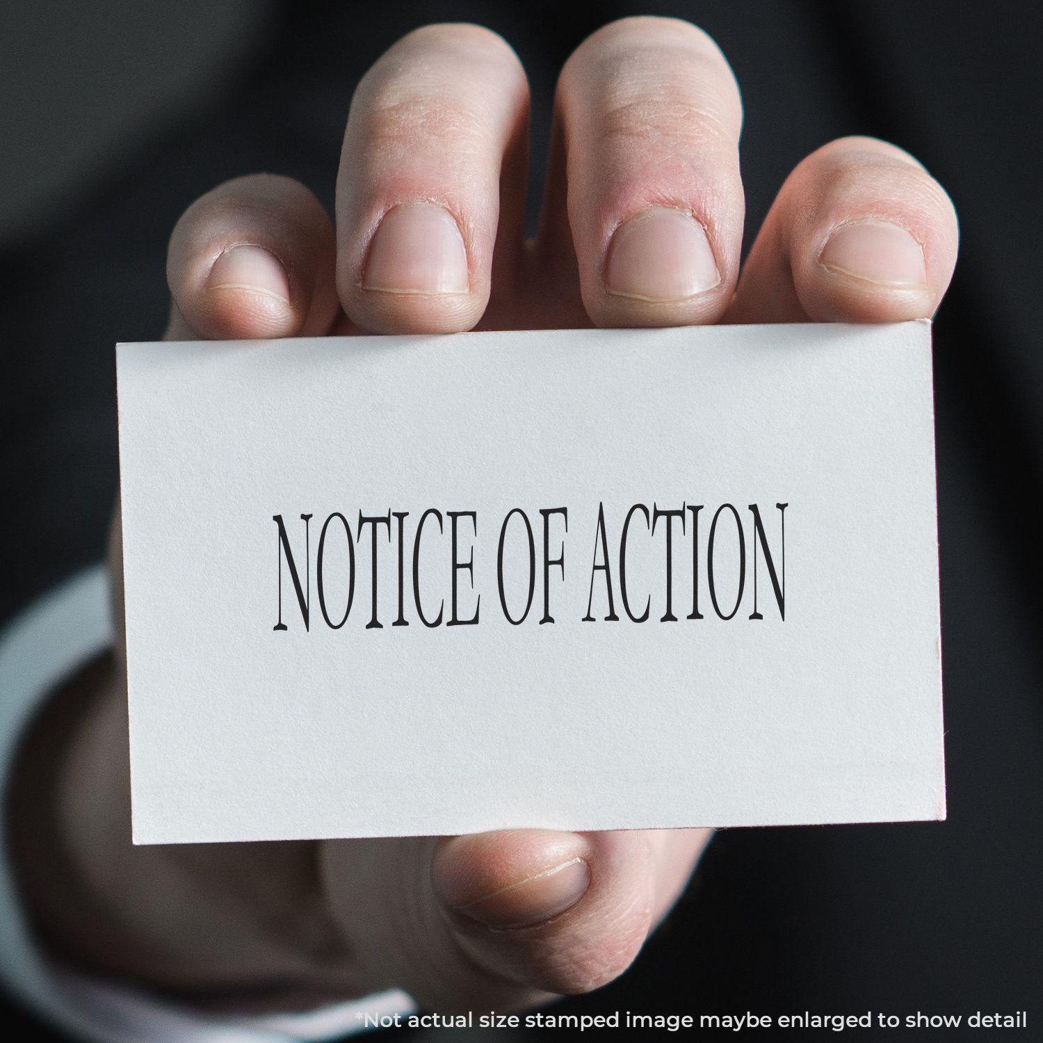 A hand holding a white card with NOTICE OF ACTION stamped in black, demonstrating the Notice Of Action Rubber Stamp.