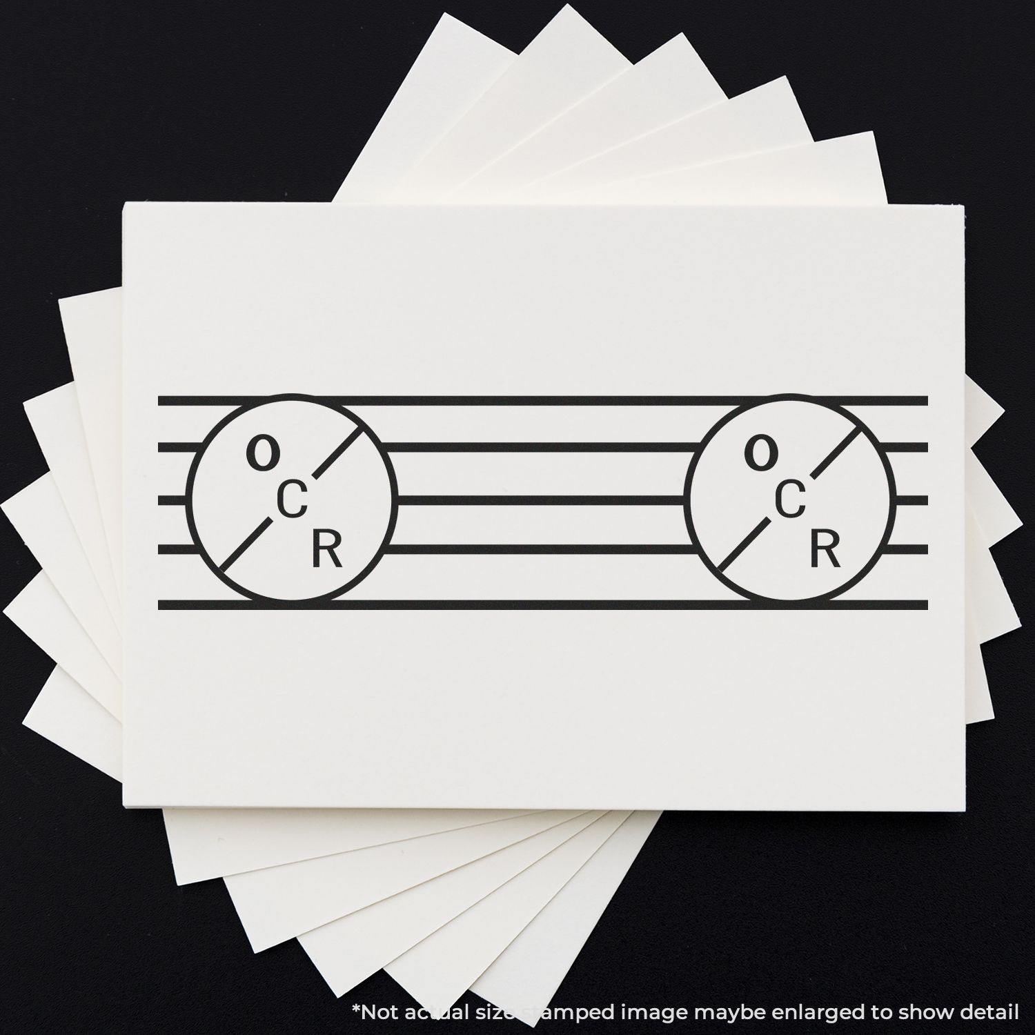 A stack of white cards with a black OCR rubber stamp design featuring two circles and horizontal lines on a black background.