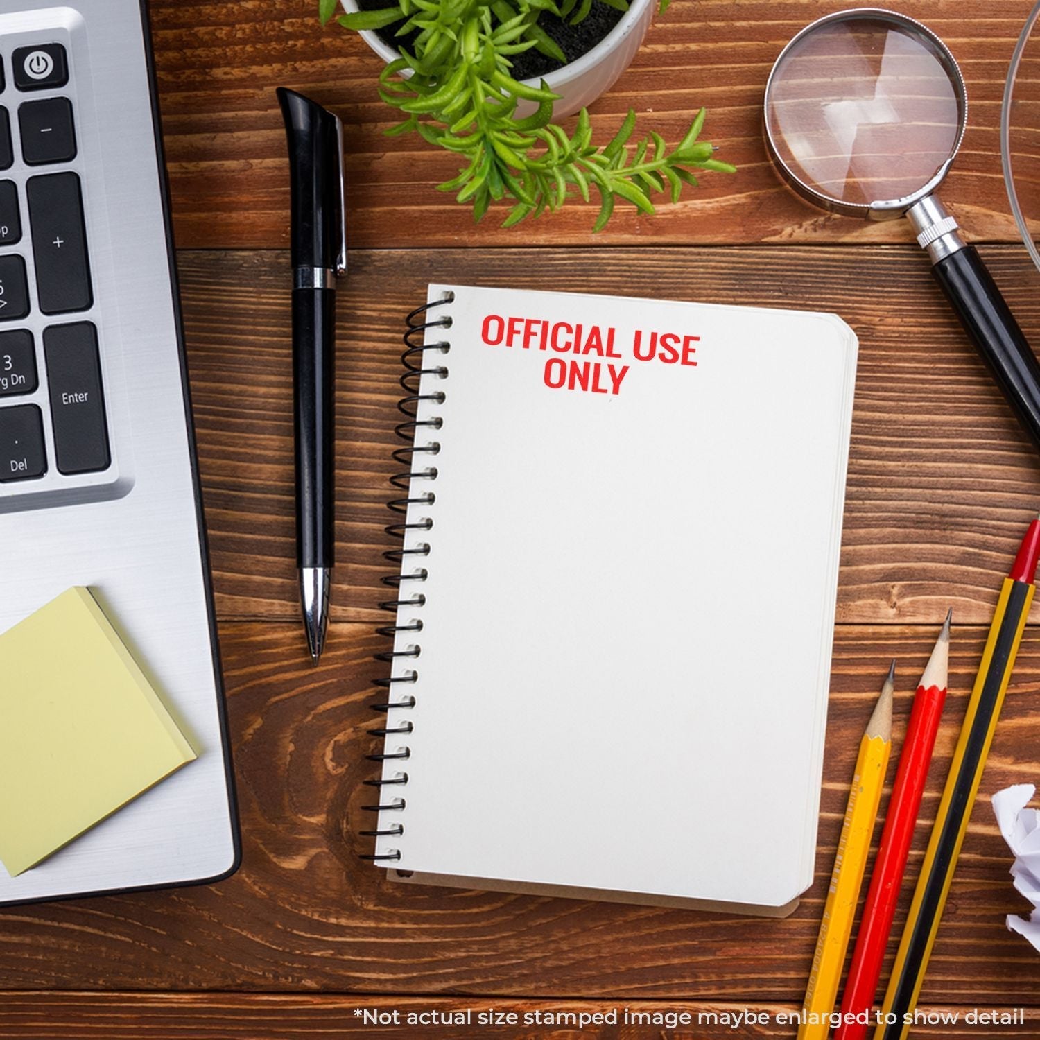 A desk with a laptop, pen, sticky notes, and a notebook stamped with OFFICIAL USE ONLY using a Self Inking Official Use Only Stamp.