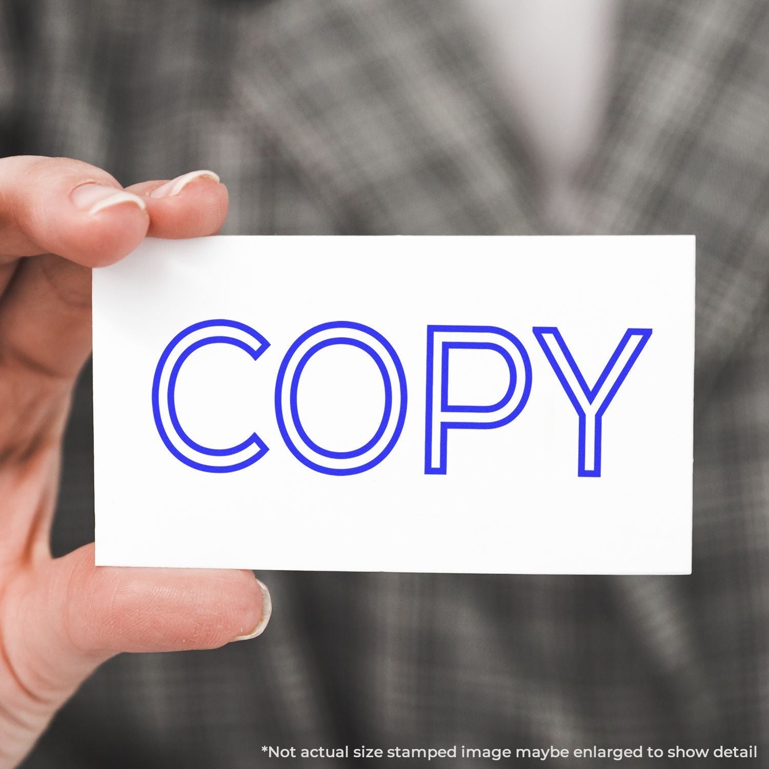 A self-inking stamp with a stamped image showing how the text "COPY" in an outline style is displayed after stamping.