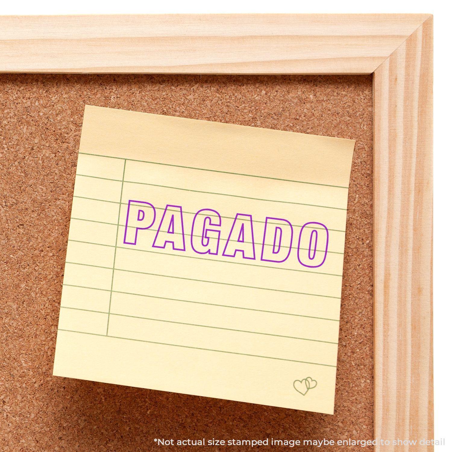 A corkboard with a sticky note stamped PAGADO in purple ink using the Large Outline Pagado Rubber Stamp.