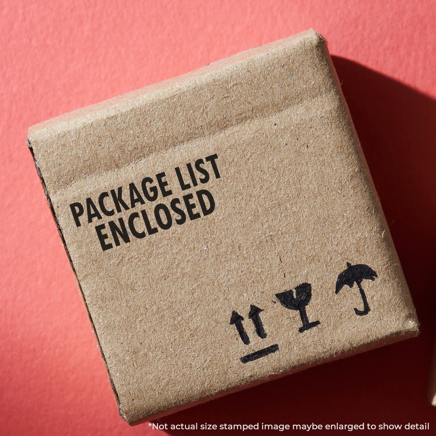 Cardboard box stamped with PACKAGE LIST ENCLOSED using the Self Inking Package List Enclosed Shipping Stamp, on a red background.