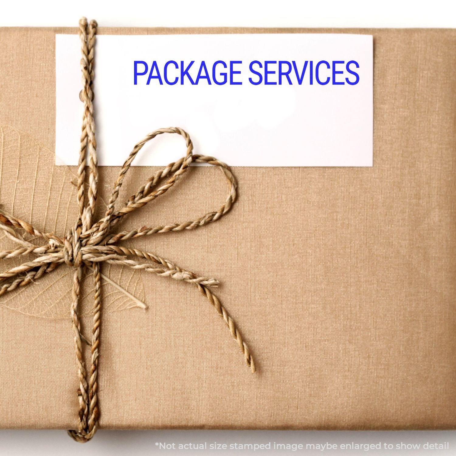 A brown package tied with twine and a white card stamped with PACKAGE SERVICES using the Large Package Services Rubber Stamp.