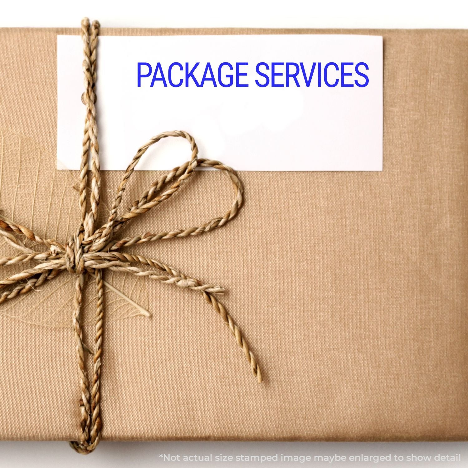 A brown package tied with twine and a white label stamped with PACKAGE SERVICES using a Self Inking Package Services Stamp.