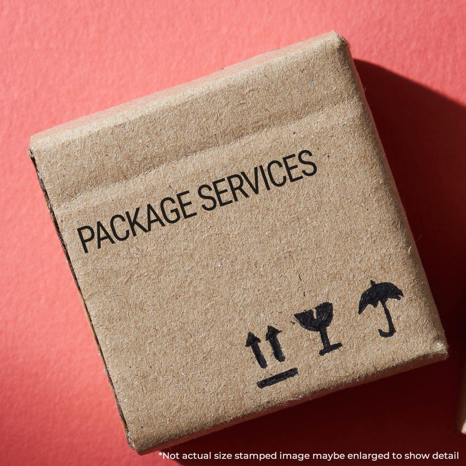 A cardboard box stamped with PACKAGE SERVICES using a Slim Pre-Inked Package Services Stamp on a red background.