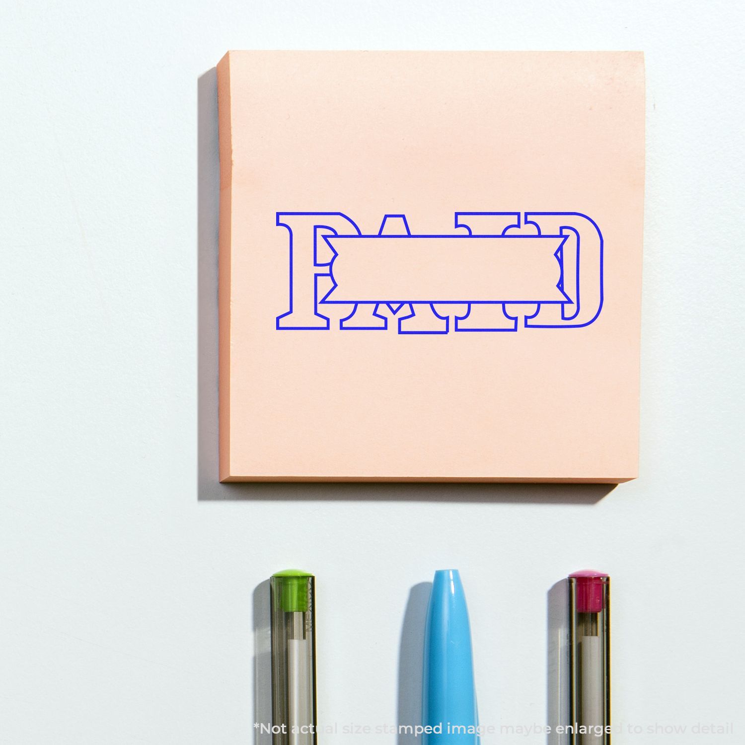 Self Inking Paid with Box Stamp in blue ink on a pink notepad, with three pens below.