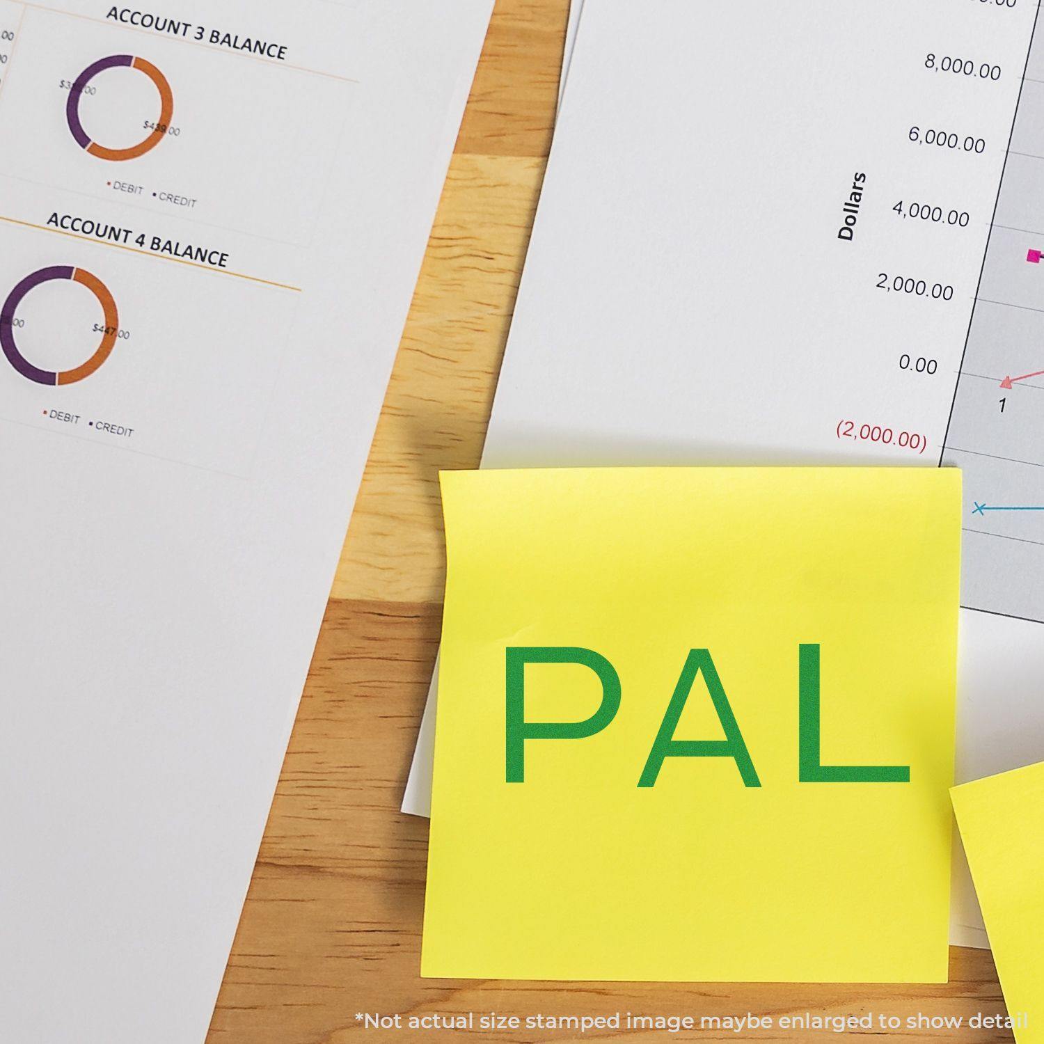 Large Pre-Inked PAL Stamp used on a yellow sticky note, placed on a wooden desk with financial documents and charts in the background.