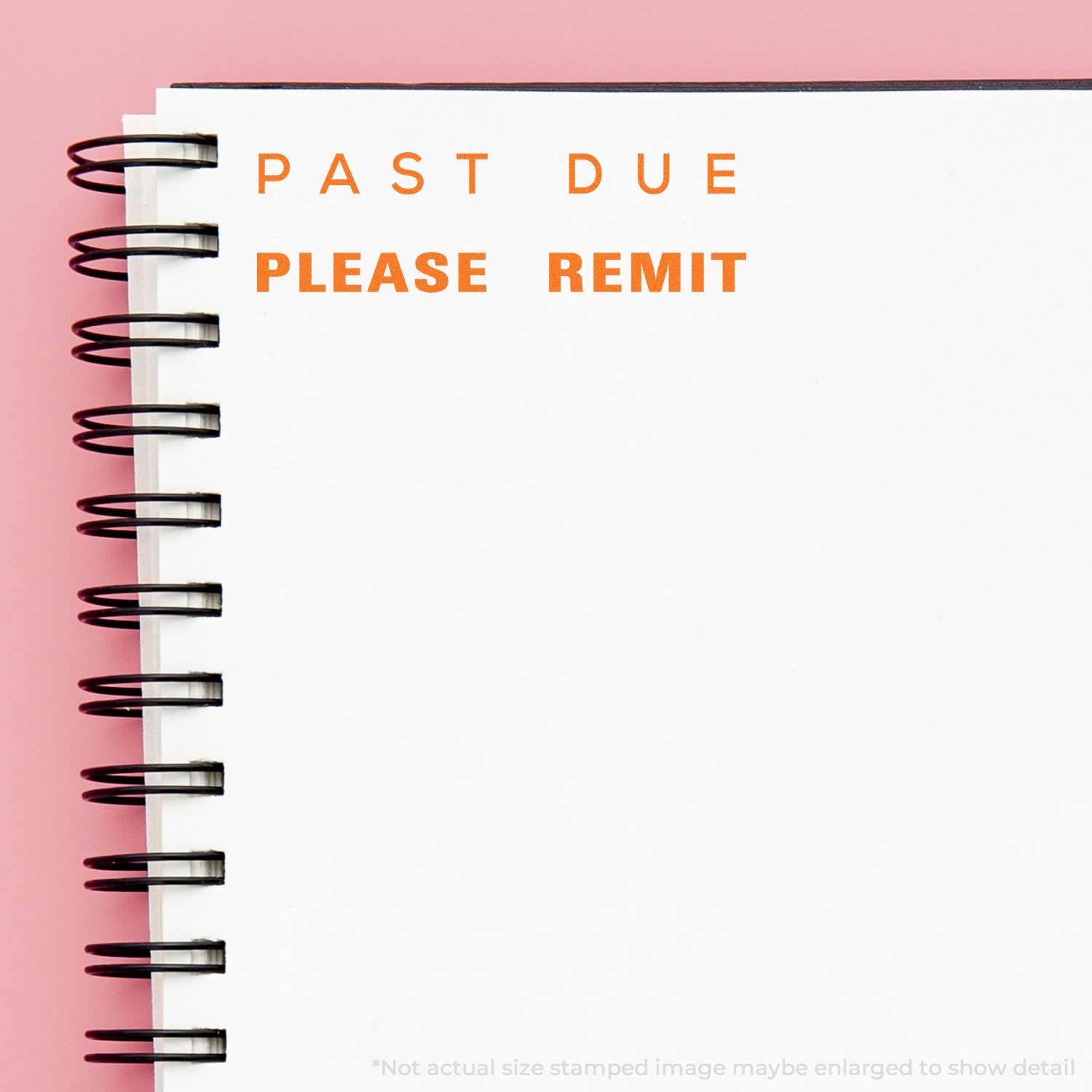 A notebook with PAST DUE PLEASE REMIT stamped in orange using the Large Past Due Please Remit Rubber Stamp on a pink background.