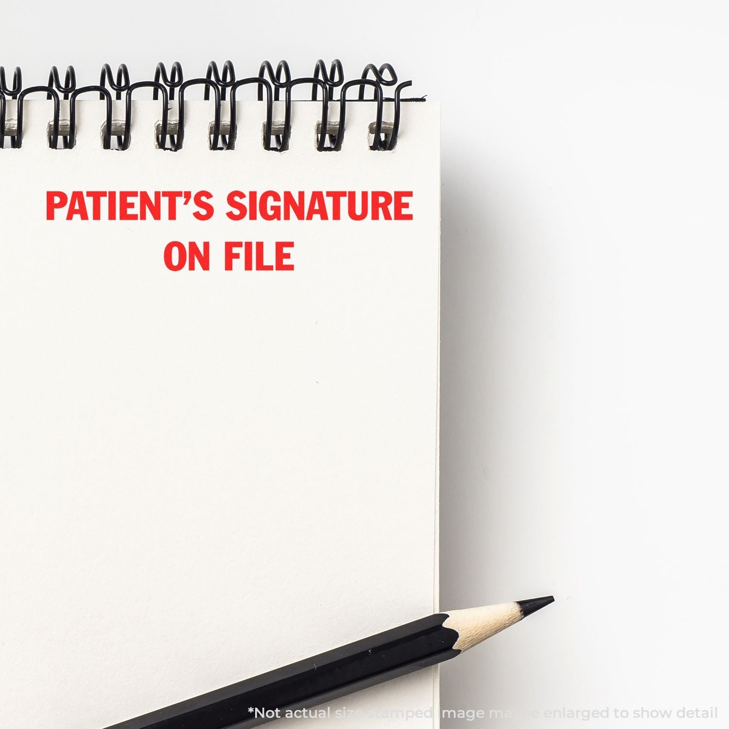 Self Inking Patient's Signature on File Stamp used on a white notepad with a pencil beside it. Text in red reads PATIENT'S SIGNATURE ON FILE.