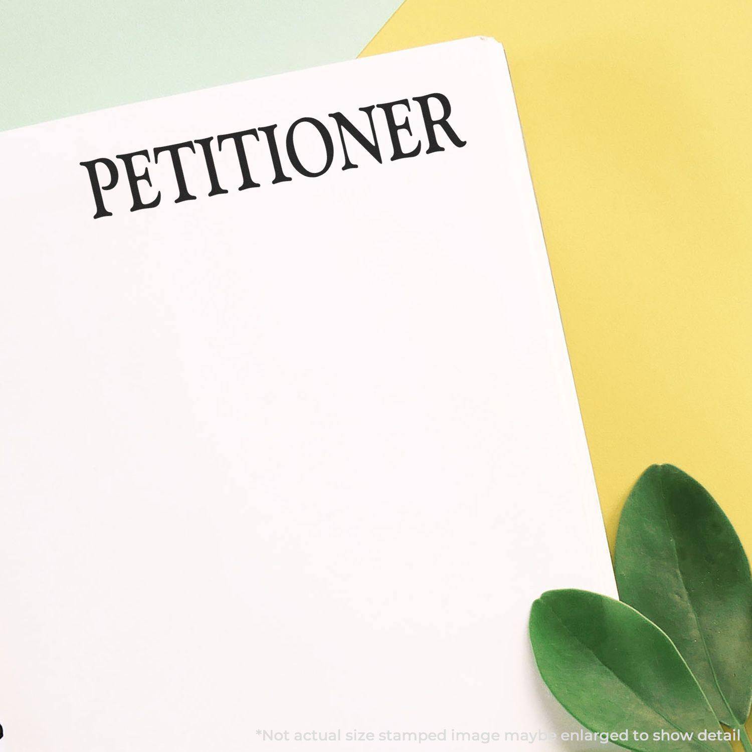 Large Petitioner Rubber Stamp imprint on white paper with green leaves and yellow background.