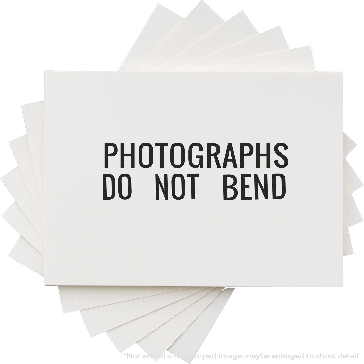 Photographs Do Not Bend rubber stamp impression on a stack of white cards, emphasizing the importance of handling with care.