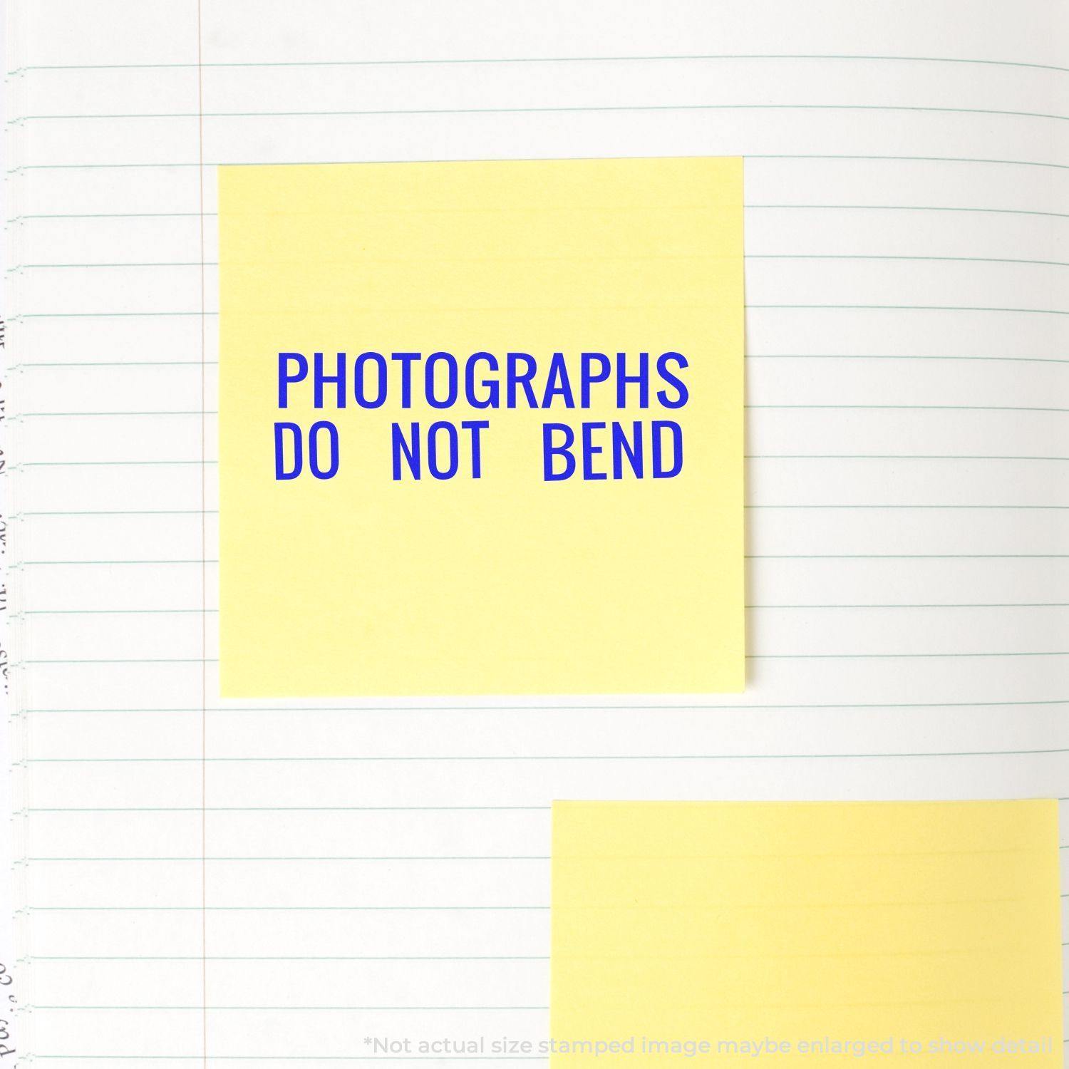 Yellow sticky note stamped with PHOTOGRAPHS DO NOT BEND in blue ink using the Large Photographs Do Not Bend Rubber Stamp on lined paper.